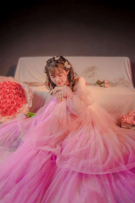  wearing a rose - adorned gown sitting in a chair