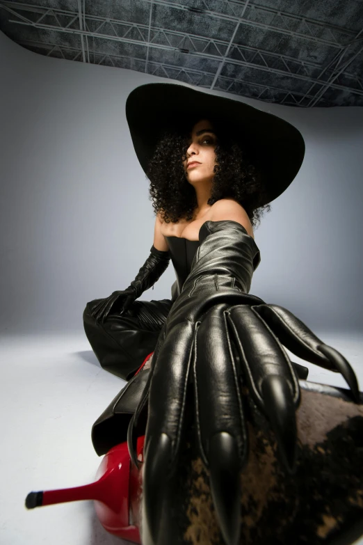 a woman with big, black leather gloves and a wide brimmed hat