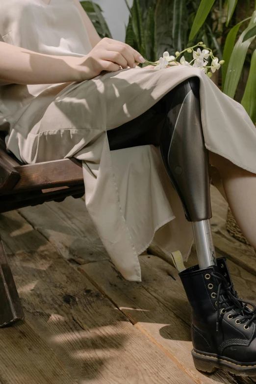 a woman with her foot on a stool near a plant