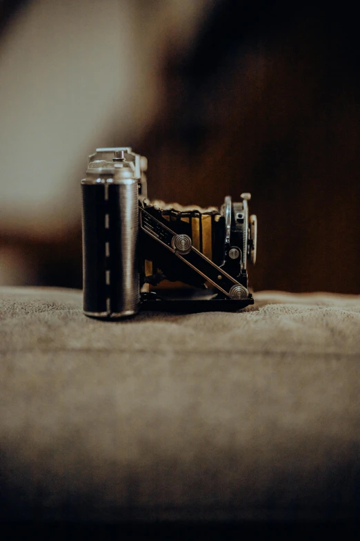 a camera is sitting on a couch with a strap