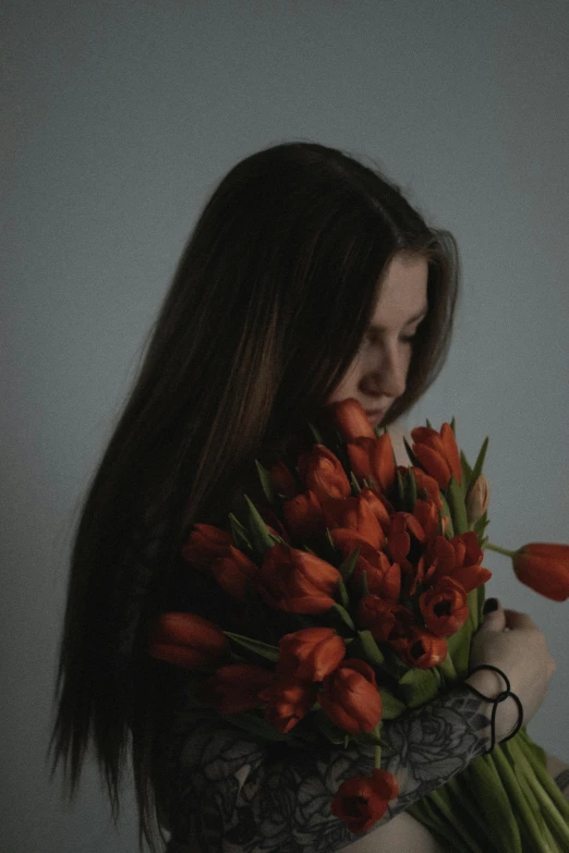 the woman with long brown hair is holding some flowers