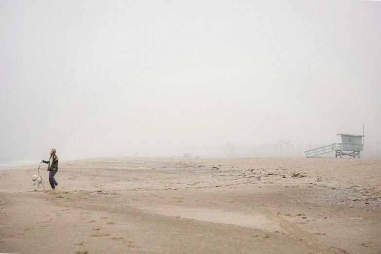 a person holding onto a kite on a beach