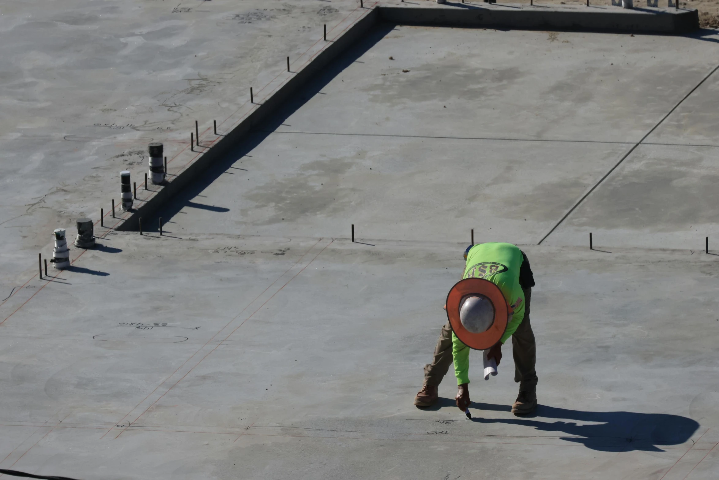 a man in a green shirt with a red frisbee standing