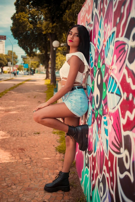 a pretty young lady leaning against a wall