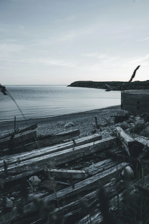 a large long wooden bench next to the beach