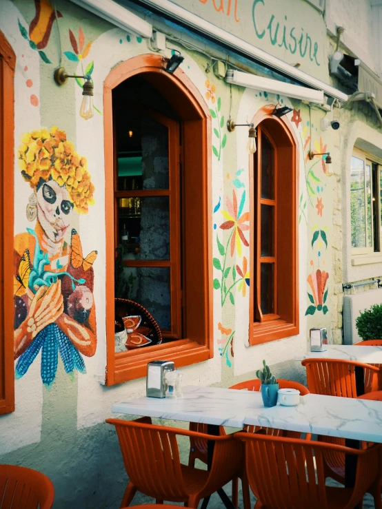 some tables and chairs are in front of a cafe