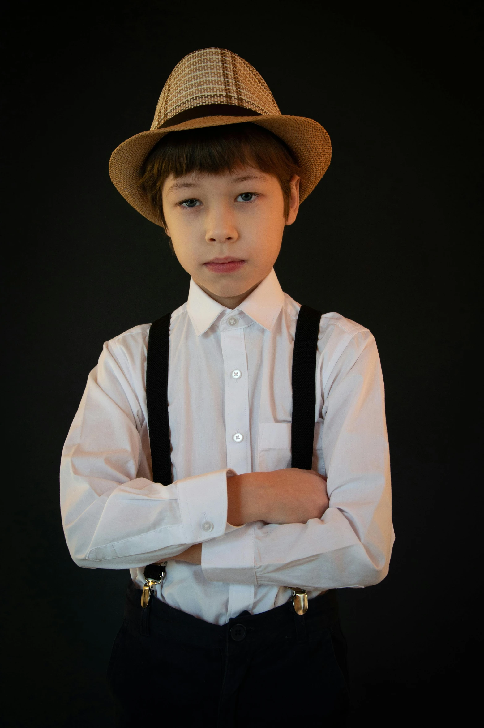 little boy in black hat with white shirt and suspenders