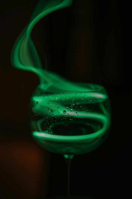 a glass filled with liquid and green and white liquid