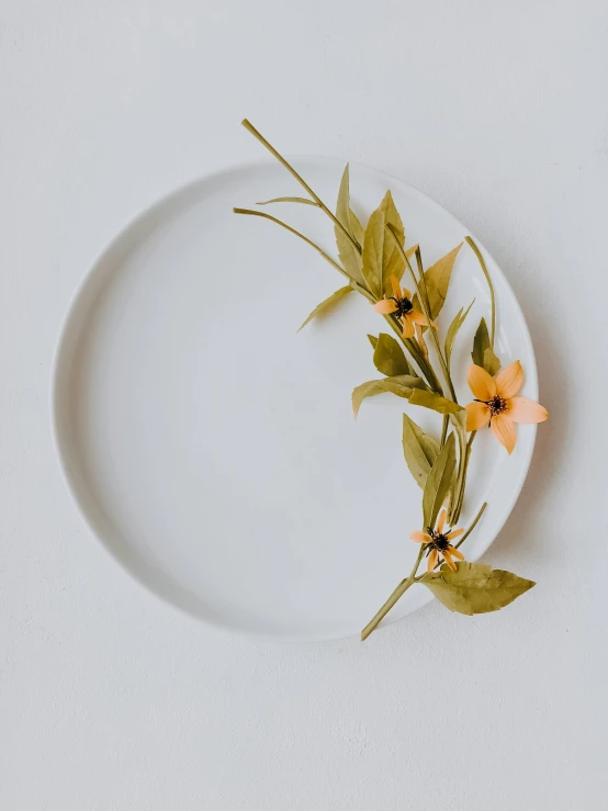 a plate with yellow flowers and greens on it