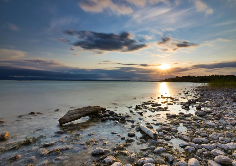 the setting sun is over the calm waters