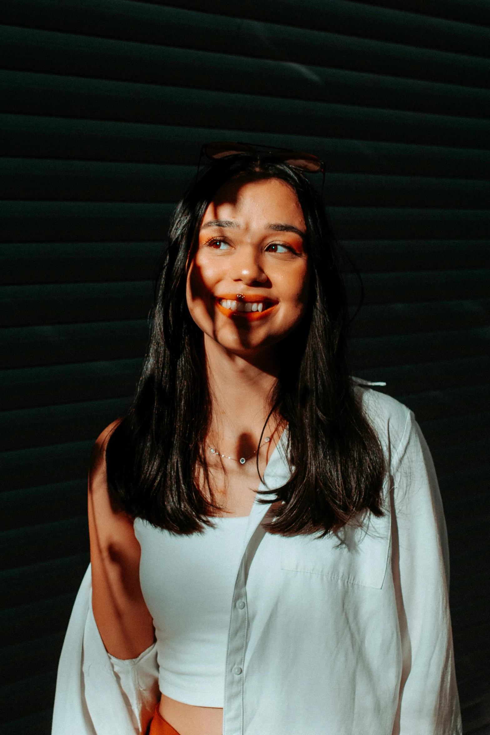 a woman is making an evil face while standing with her hand up to her mouth