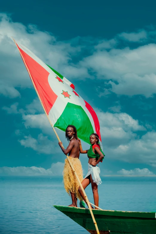 two girls standing on the back of a boat while holding a flag