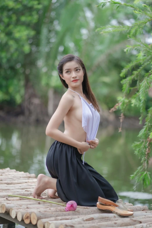 a beautiful young lady sitting on a wooden dock