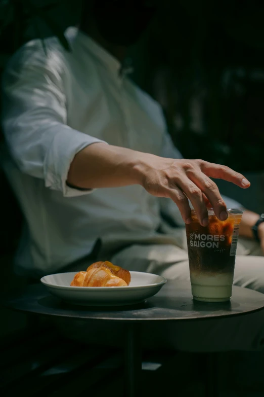 a hand reaching for food on a plate