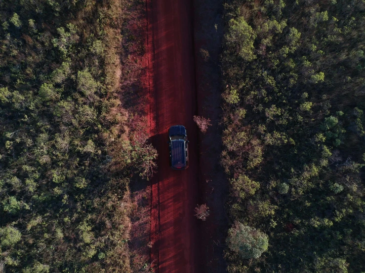 a blue car parked along a dirt road