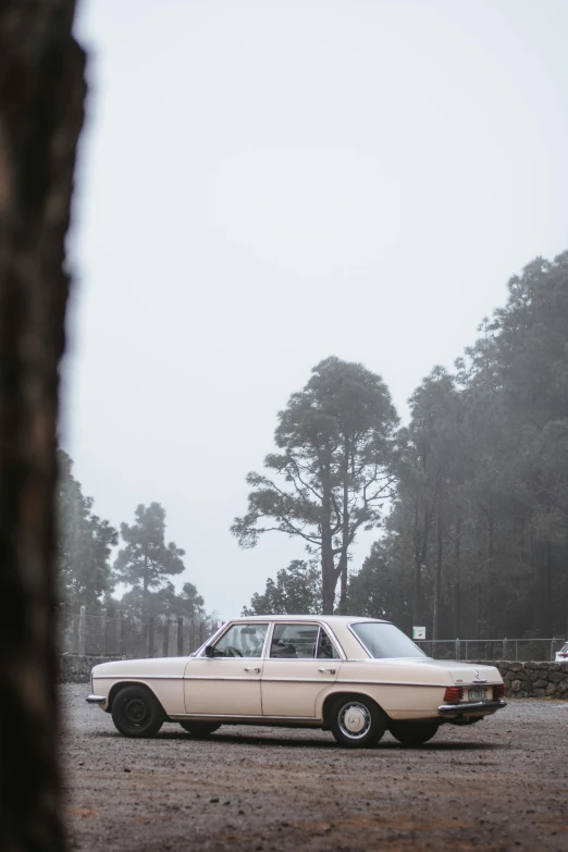 a white car parked on top of a dirt field