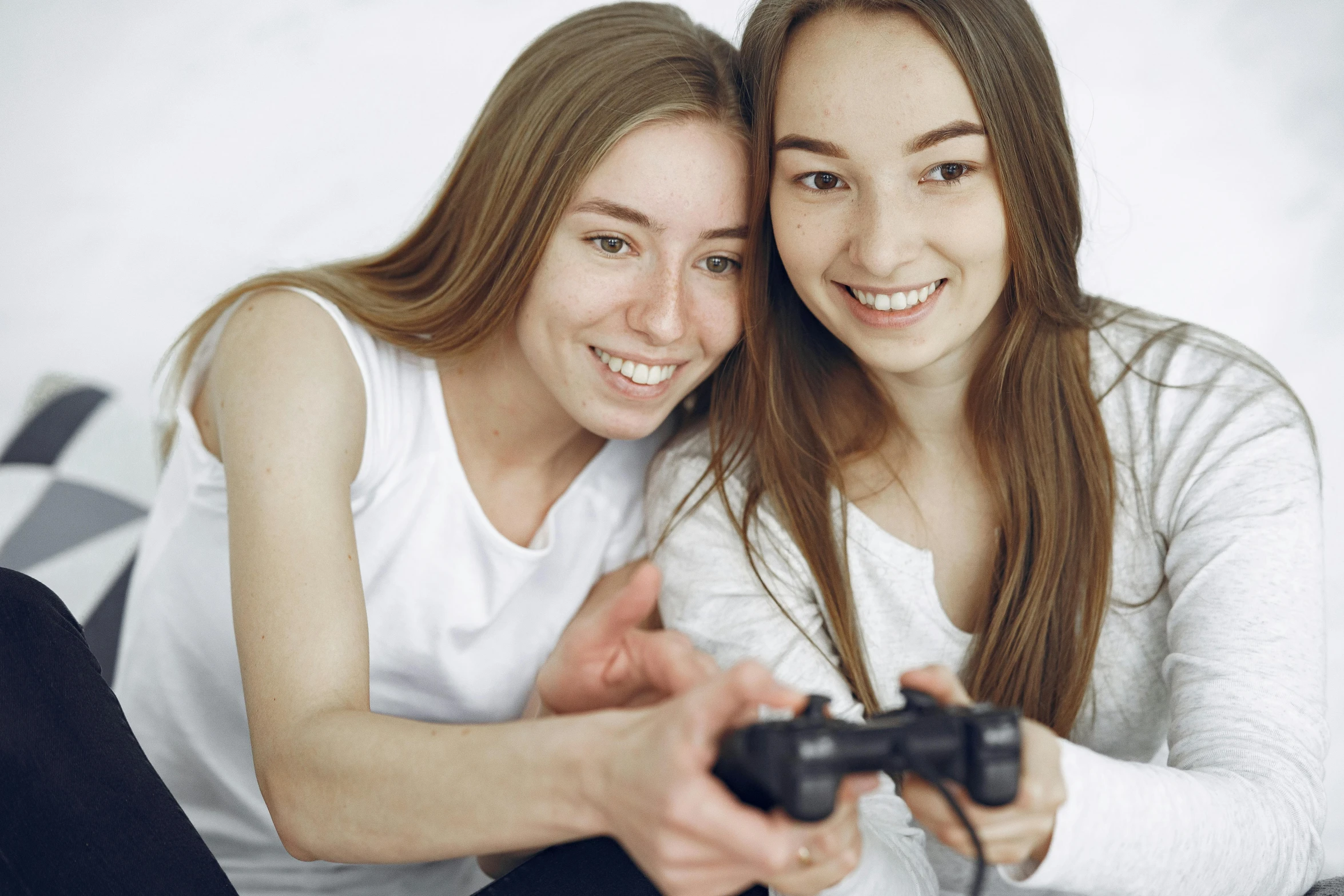 two young women are smiling and playing the nintendo wii together