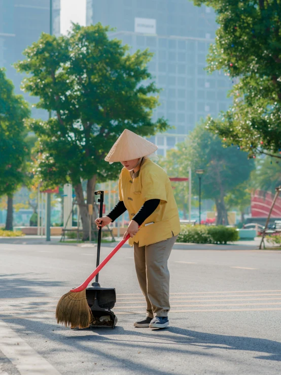 a person is using a broom to dig through the pavement