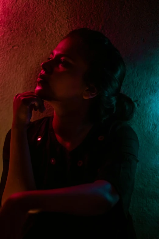 a woman sitting in front of a red and green light