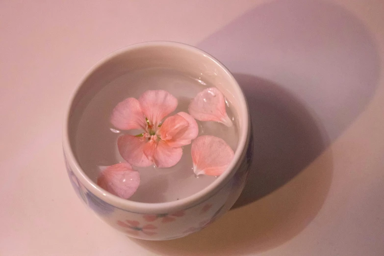 pink flowers are placed in a small cup
