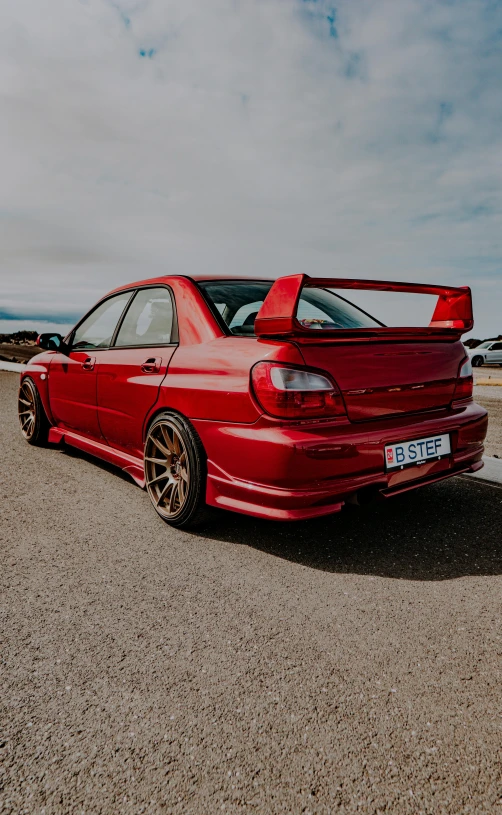 an orange car parked on a gravel road