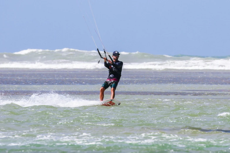 a man kite boarding and holding a rope above the water