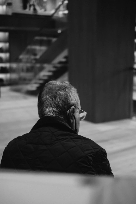 the man is sitting on the bench reading