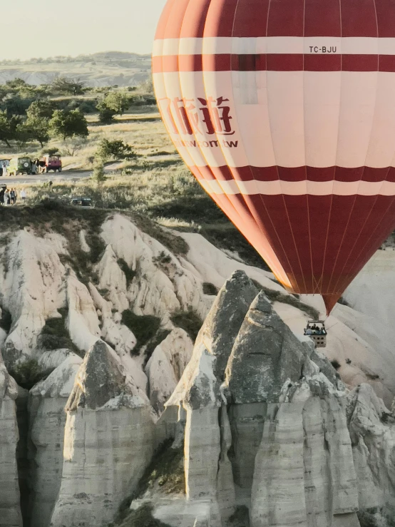 a  air balloon rising up in the sky over rock formations