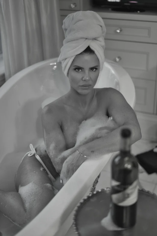 a  woman sitting in a bathtub with soap on it