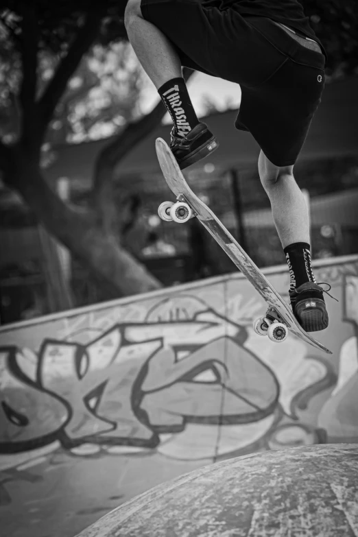 black and white pograph of person jumping on a skateboard
