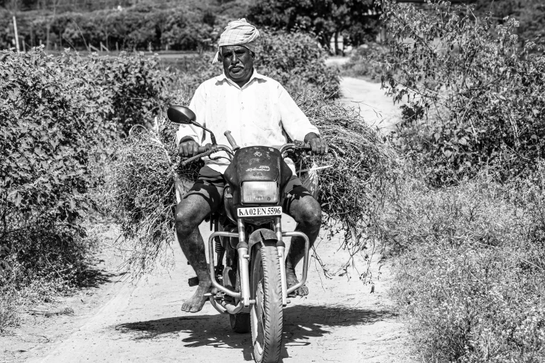 a man riding a motorcycle down a dirt road