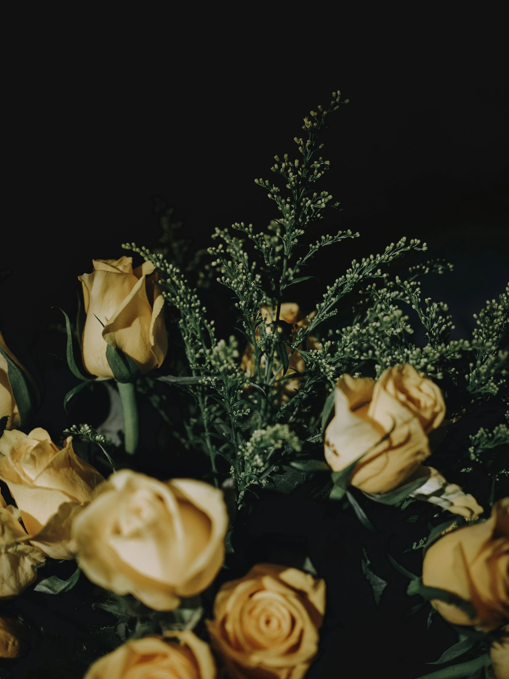 a bouquet of flowers on a table in the dark