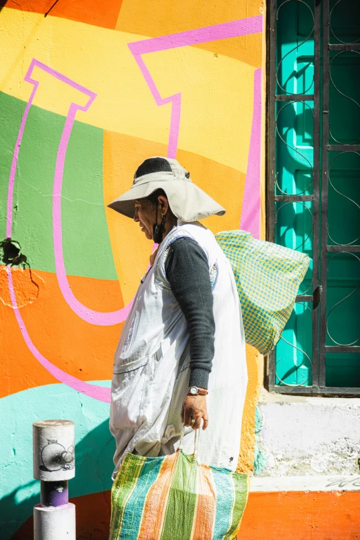 a person in a big hat is carrying a bag and backpack