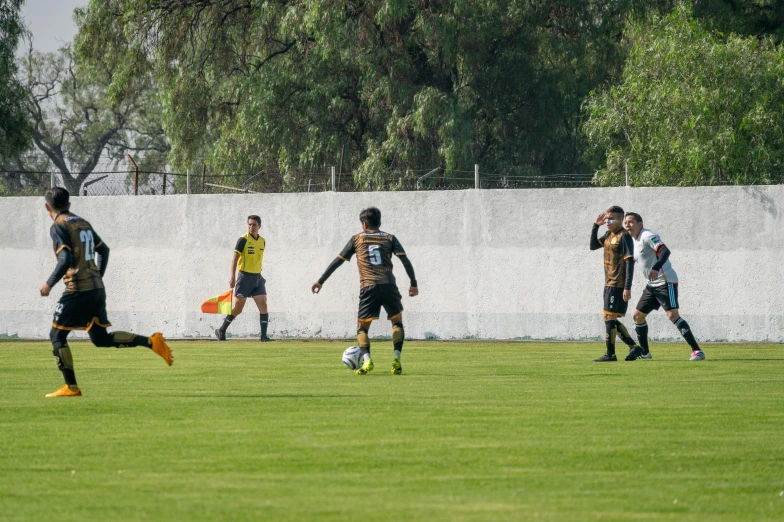 a group of young men are kicking around a soccer ball