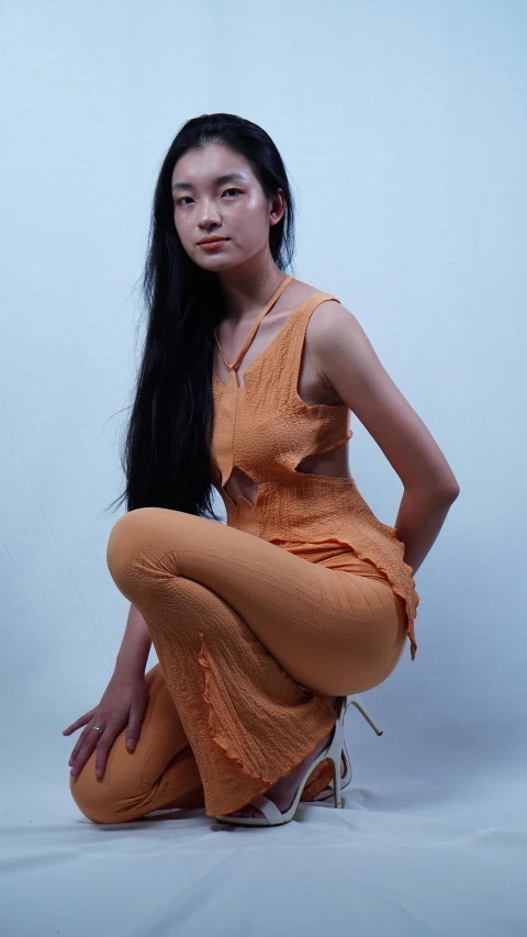 a woman with long hair in tight dress sitting on the floor