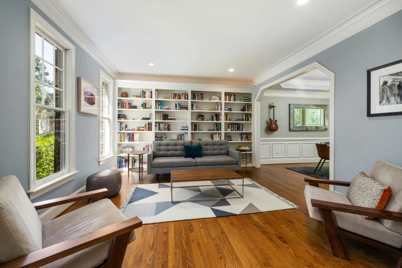 a living room with wood floors and an open book case