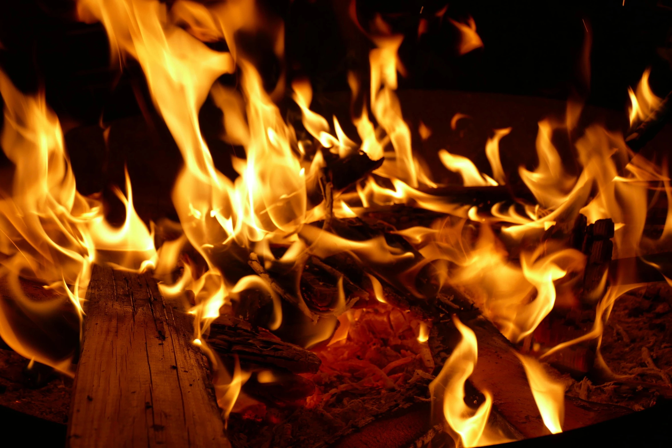 a fire burning through a wooden burning pan