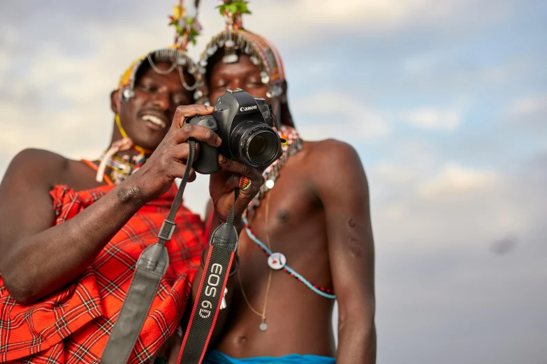 a couple of women holding a camera up