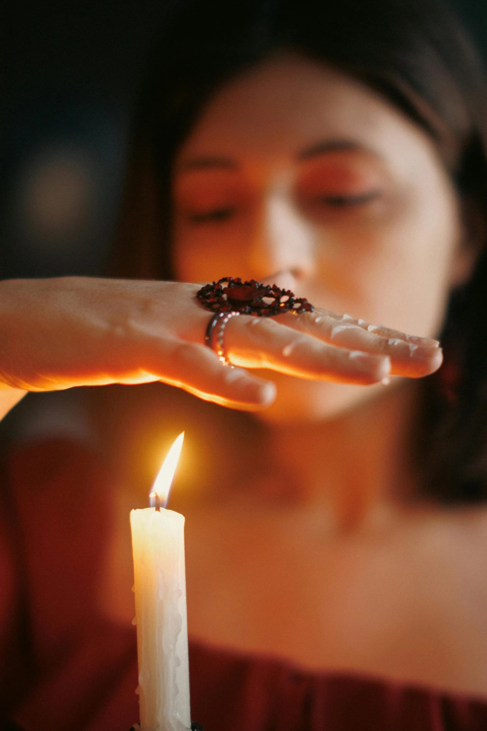 a person holding a candle and some sort of soing on their finger