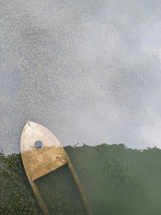 an old paddle boat is floating in a pond