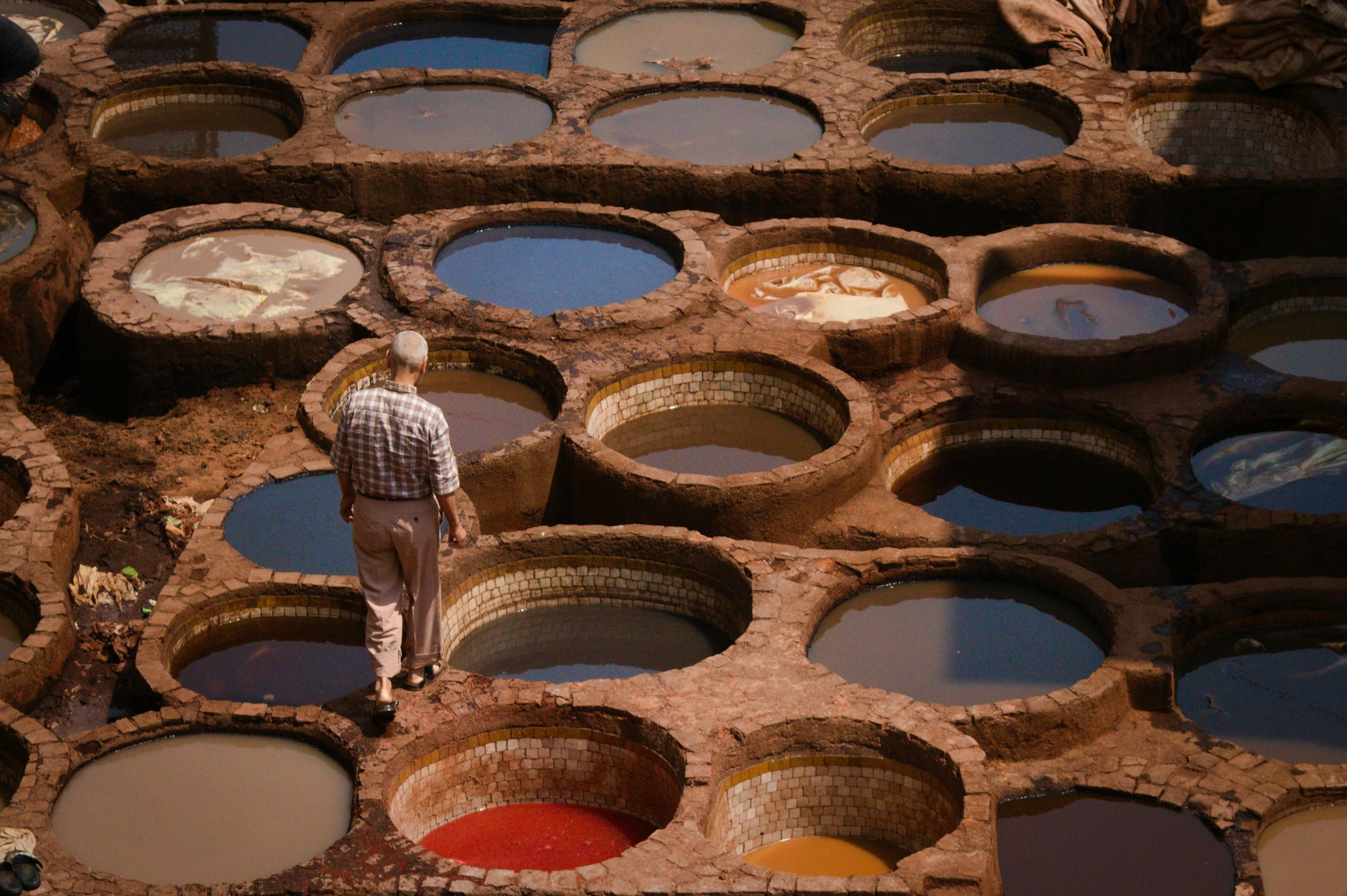 a man looking inside of some dirty buckets