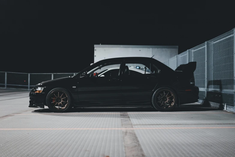 a black car parked outside of a building at night