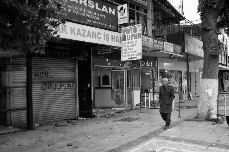 the man in suit and tie is walking down the sidewalk