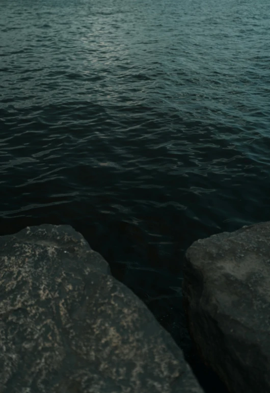 some dark water some rocks and some hills