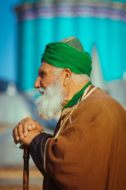 an old man with a beard and white mustache standing near a structure