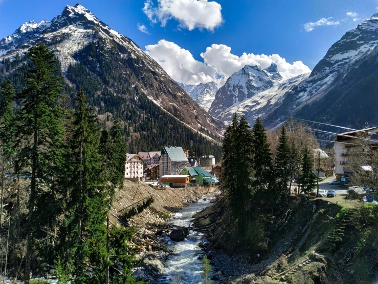 the valley and mountains surrounding a town near a river