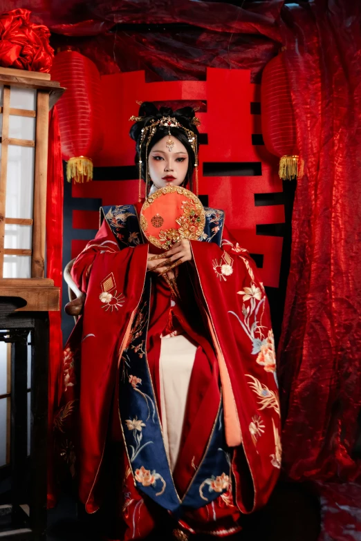 a geisha in traditional japanese clothes holding a red lantern