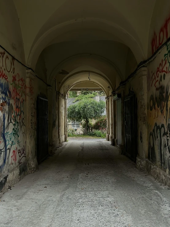 a tunnel is decorated with graffiti and doors