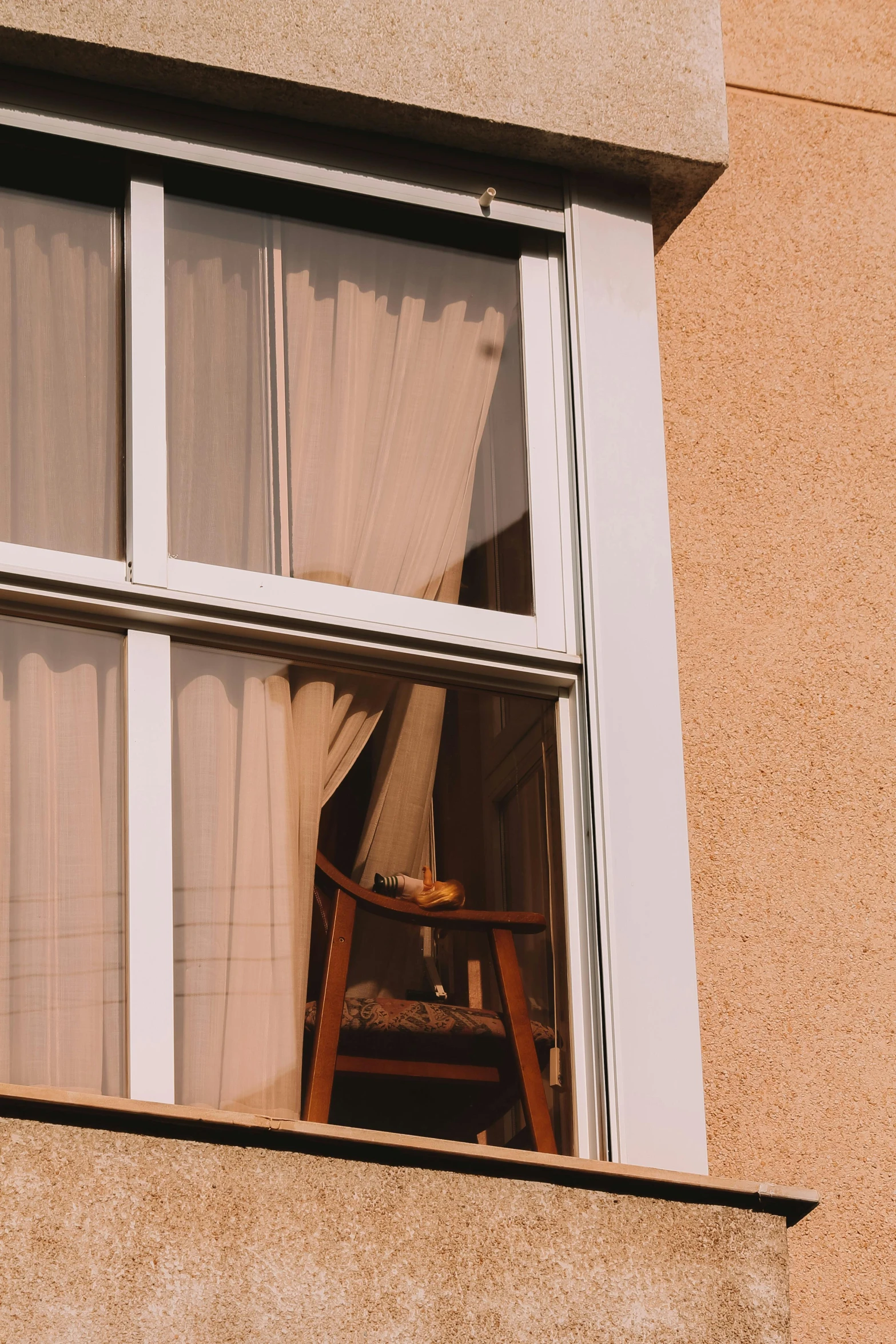 a wooden chair near a window with curtains