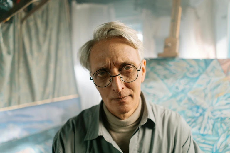 an elderly man wearing glasses sits in a boat